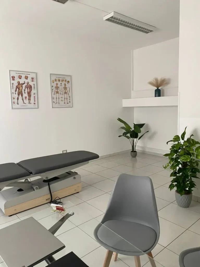 Sala trattamenti con lettino, sedia e piante